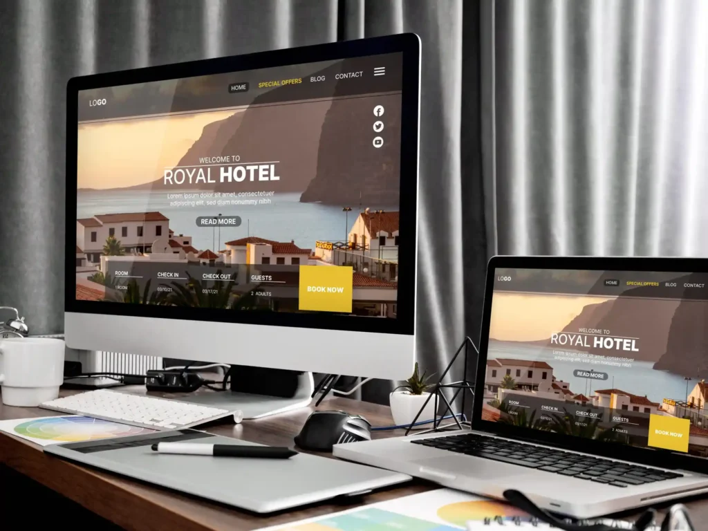A desktop computer and a laptop displaying a hotel website with a booking interface, showcasing Weblook International's creative web design services in Sri Lanka.