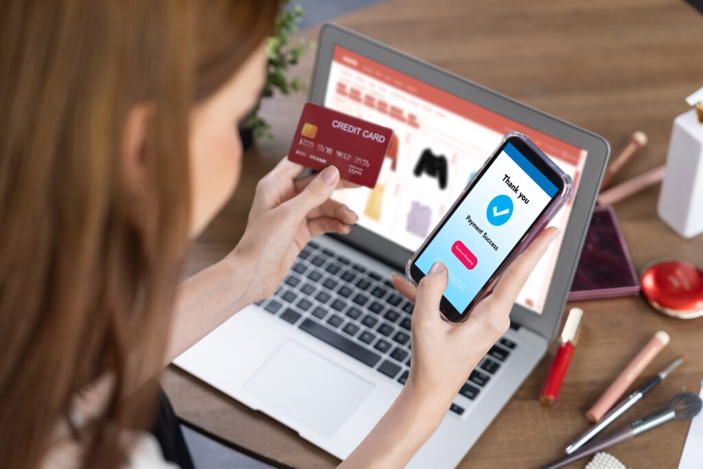The image depicts a woman shopping using both the laptop and a mobile device. The activity is possible due to responsive web design.