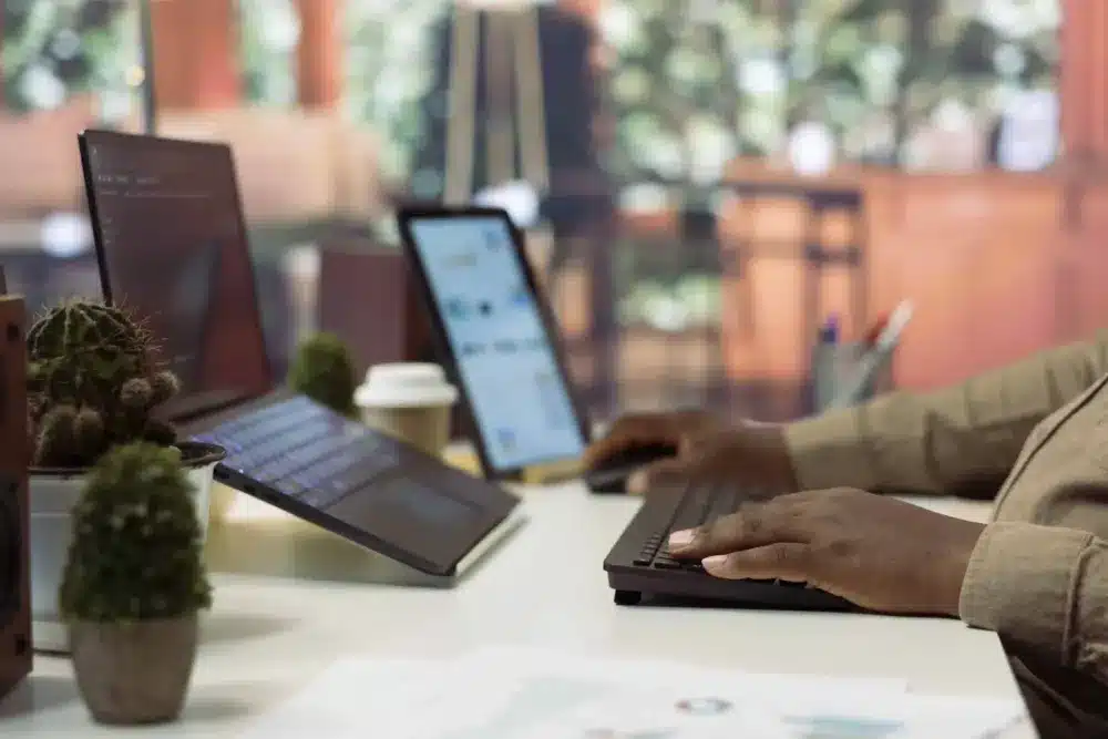 A professional working on a laptop and tablet in a modern workspace, showcasing Weblook’s dedication to cutting-edge technology and efficient design practices.